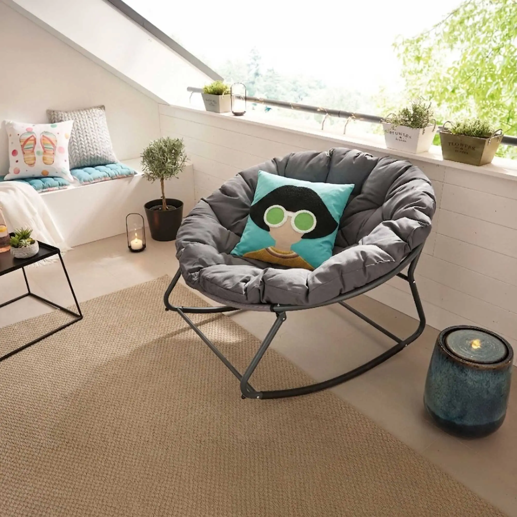 Wohninspiration: gemütliche Leseecke mit grauem Schaukelstuhl, Kissen, Pflanze und Teppich