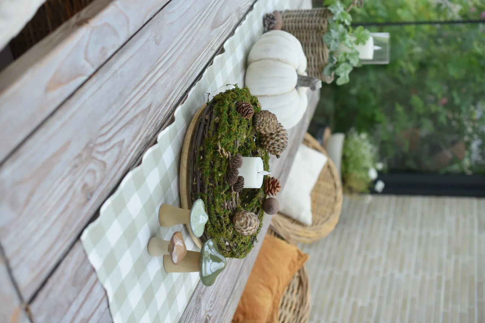 Herbstdeko: Mooskranz mit Zapfen, Kerze und Keramikpilzen als natürliche Tischdekoration