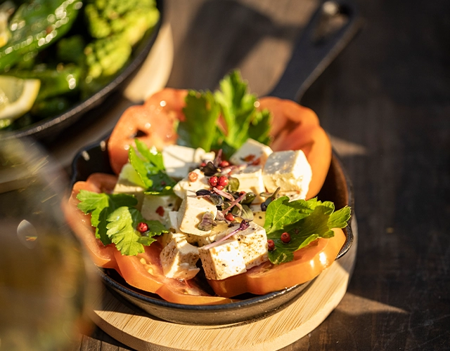 Tischdeko: Gusseisen‑Pfännchen mit Käsewürfeln, Kräutern und Gewürzen als Gartenparty‑Snack