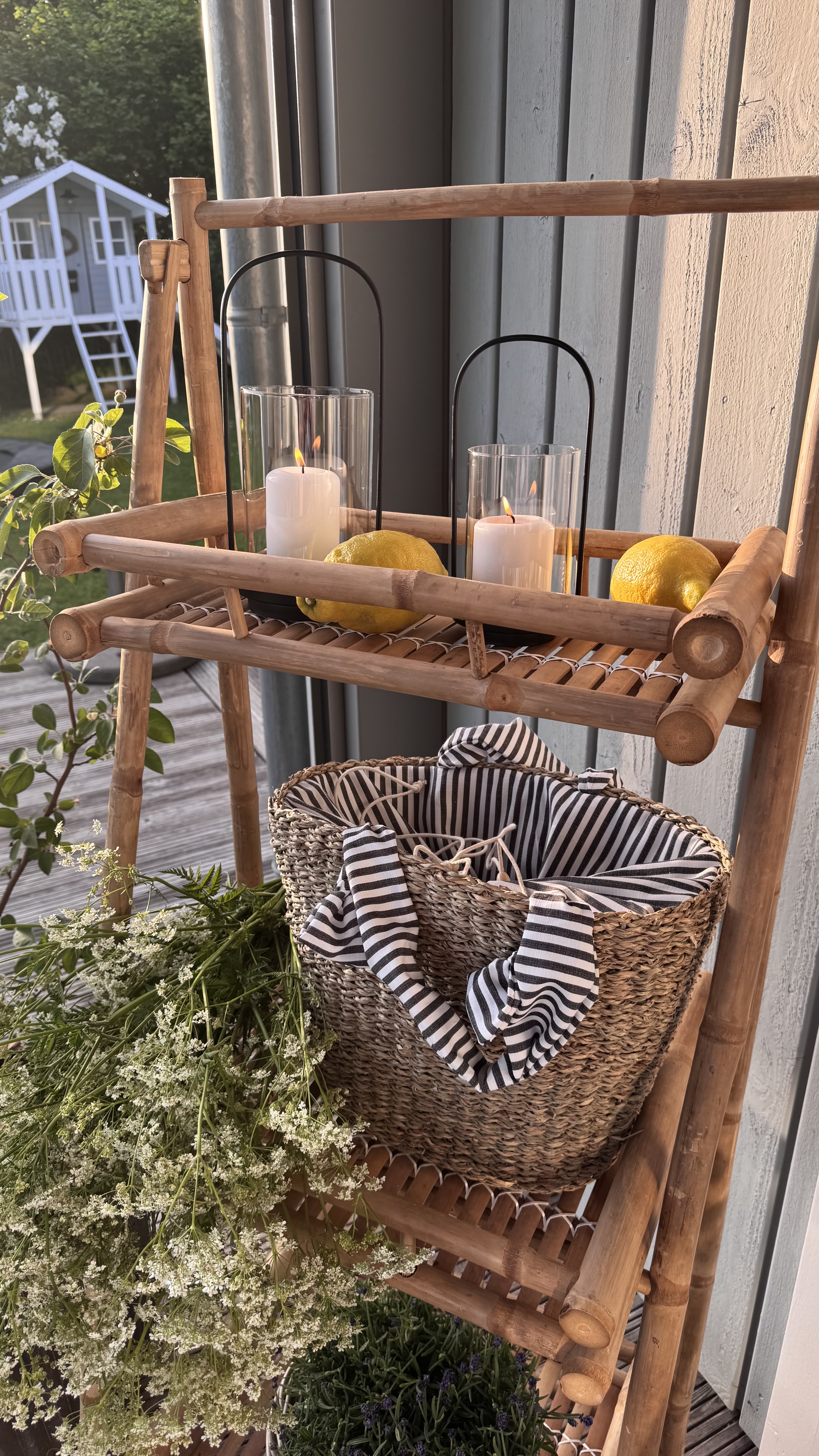 Gartendeko: Bambusregal mit Laternen, Zitronen und Korb als natürliche Terrassendekoration