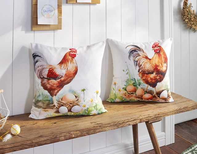 Wohntextilien: weiße Kissen mit Hahnmotiv und Eiern als rustikale Landhausdeko