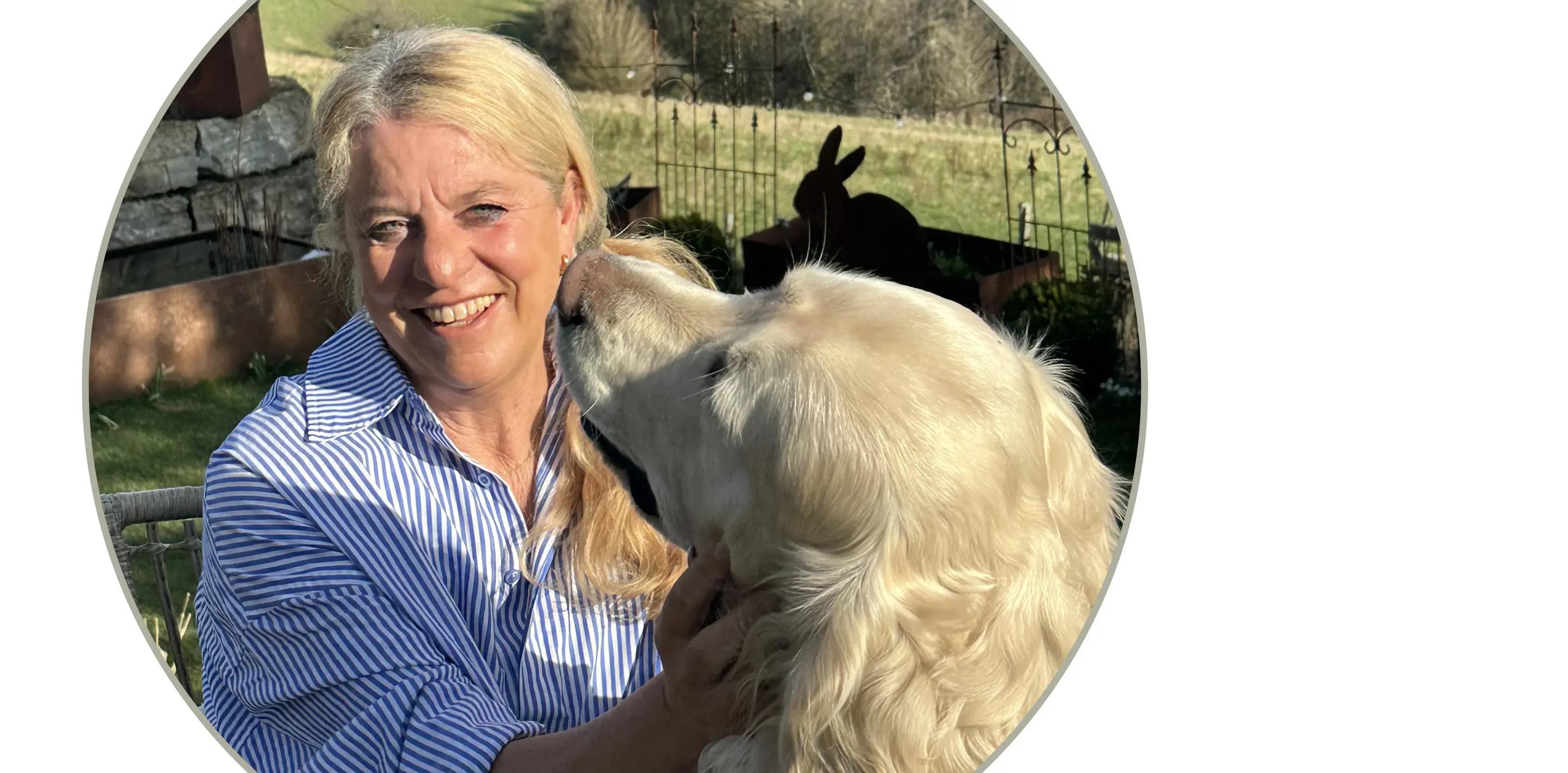 Tierfoto: große helle Hundeschnauze, die einer Person nahekommt, draußen im Gartenbereich