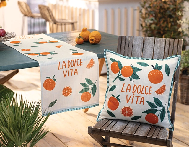 Wohntextilien: Tischläufer und Kissen mit Orangenmotiv als sommerliche Terrassen‑ und Tischdeko