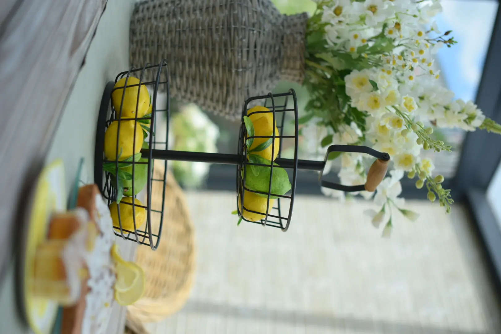 Tischdeko: schwarze Etagere mit Zitronen und weißen Blüten als sommerliche Dekoration