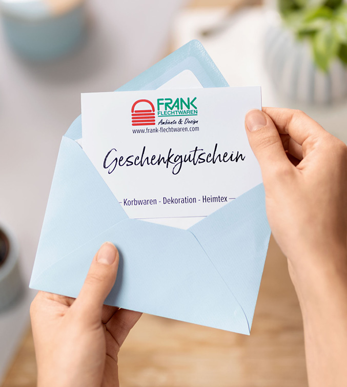 Ein Geschenkgutschein im blauen Umschlag wird geöffnet