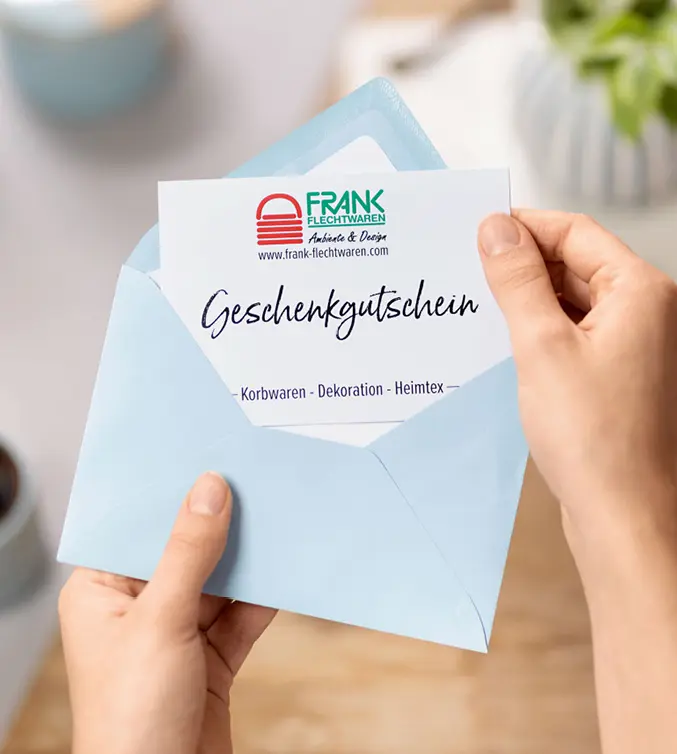 Ein Geschenkgutschein im blauen Umschlag wird geöffnet