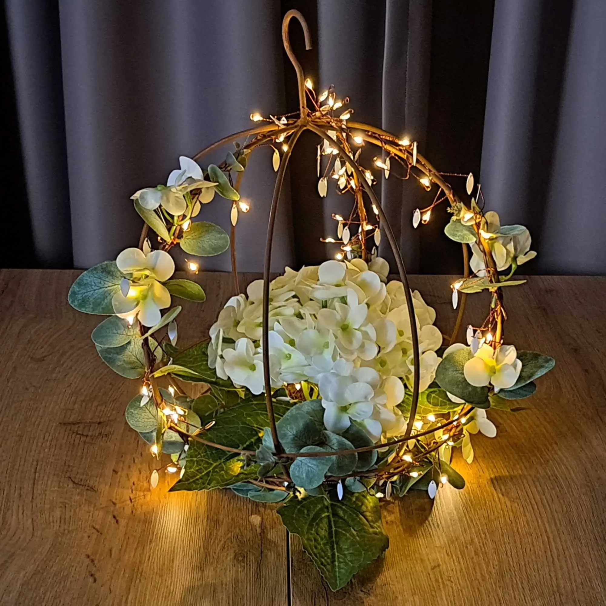 LED‑Leuchtdeko: Metall‑Hängekugel mit warmem Lichterdraht, weißen Blüten und grünen Blättern