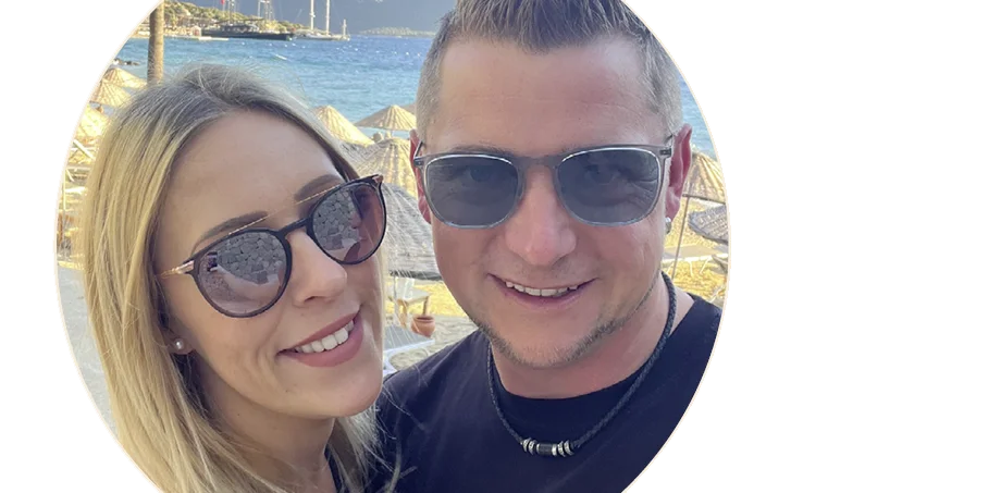 Lifestyle: zwei Personen mit Sonnenbrillen vor Strand und Meer als sommerliche Urlaubsszene
