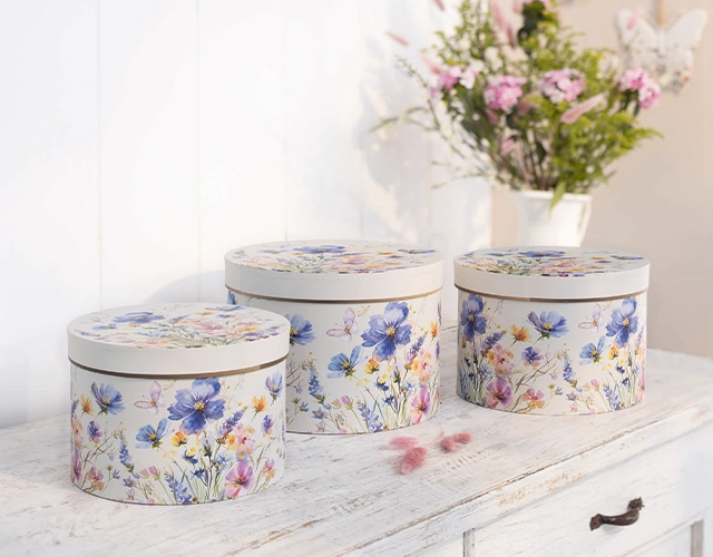 Aufbewahrungsdosen: drei runde Dosen mit buntem Blumenmuster als dekorative Geschenk- und Ordnungsdosen