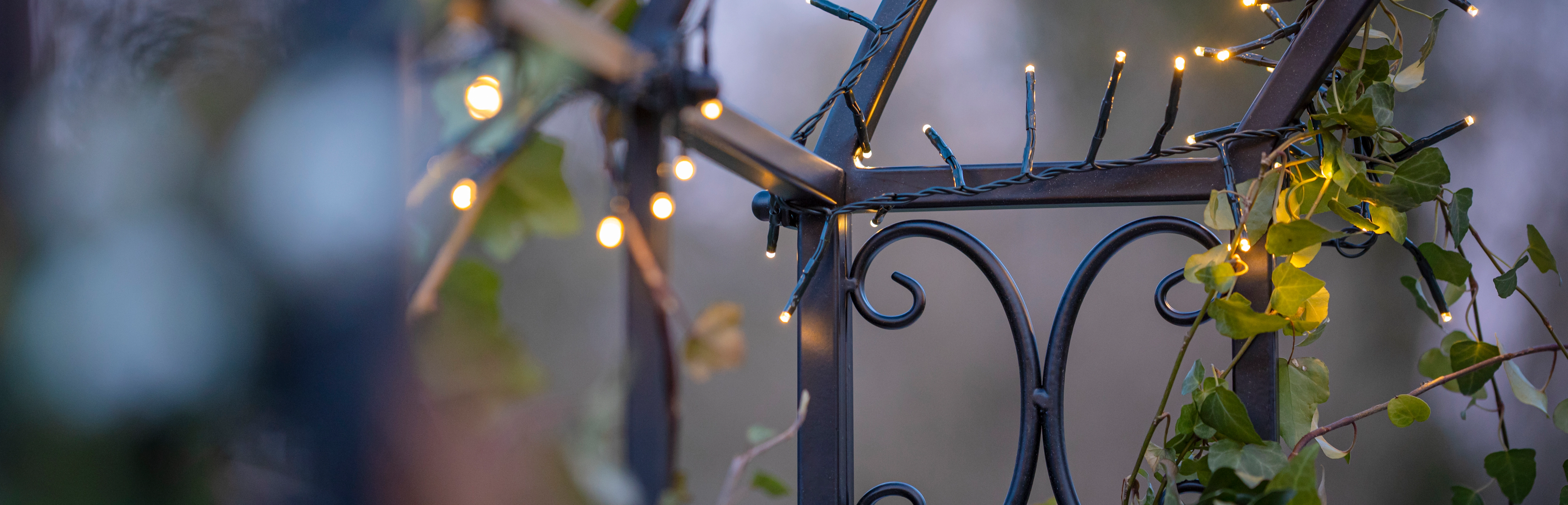 LED‑Leuchtdeko: Metallgestell mit warmweißer Lichterkette und Efeu im Gartenbereich