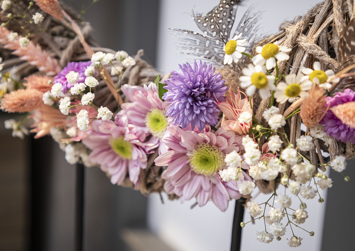 Das Bild ziegt einen Dekokranz. Dekoriert mit Blumen