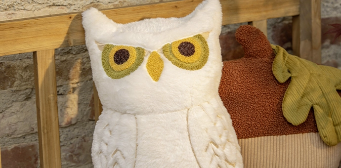 Wohntextilien: weißes Eulenkissen und Blattkissen als herbstliche Dekoration im Wohnbereich