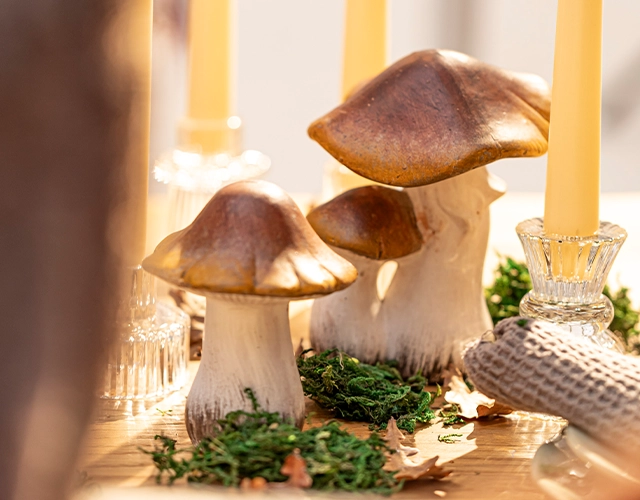 Herbstdeko: Keramikpilze mit Moos und Stabkerzen als natürliche Tischdekoration