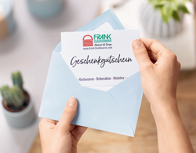 Geschenkgutschein: blauer Umschlag mit Gutschein für Korbwaren, Dekoration und Heimtextilien