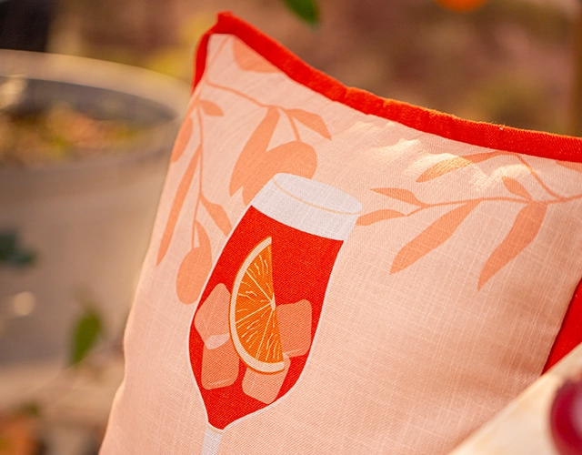 Wohntextilien: helles Kissen mit Orangenmotiv als sommerliche Tisch‑ und Terrassendeko