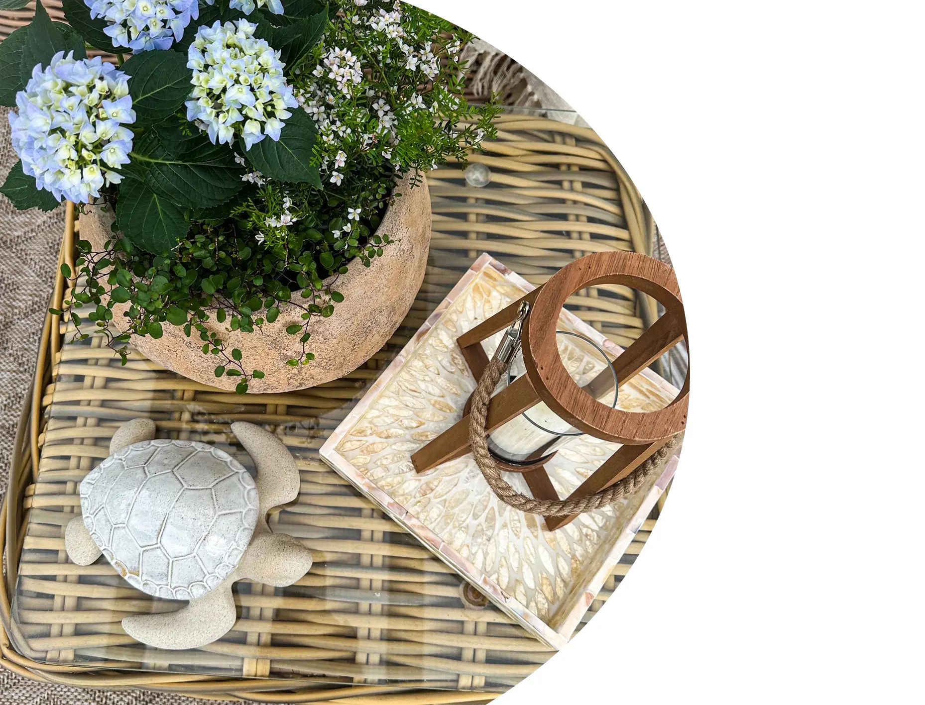 Gartendeko: Rattan‑Tablett mit Laterne, Hortensien und Schildkrötenfigur als Terrassendekoration