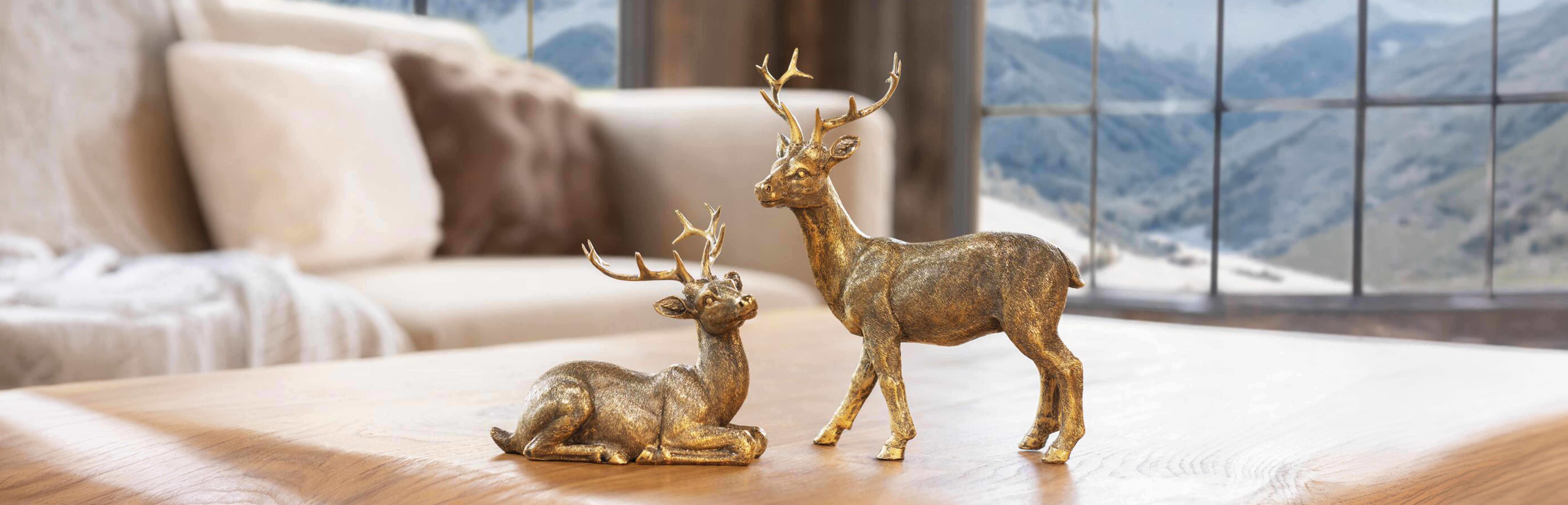 Weihnachtsdeko: goldene Hirschfiguren auf Holztisch als stilvolle Winterdekoration im Chaletstil