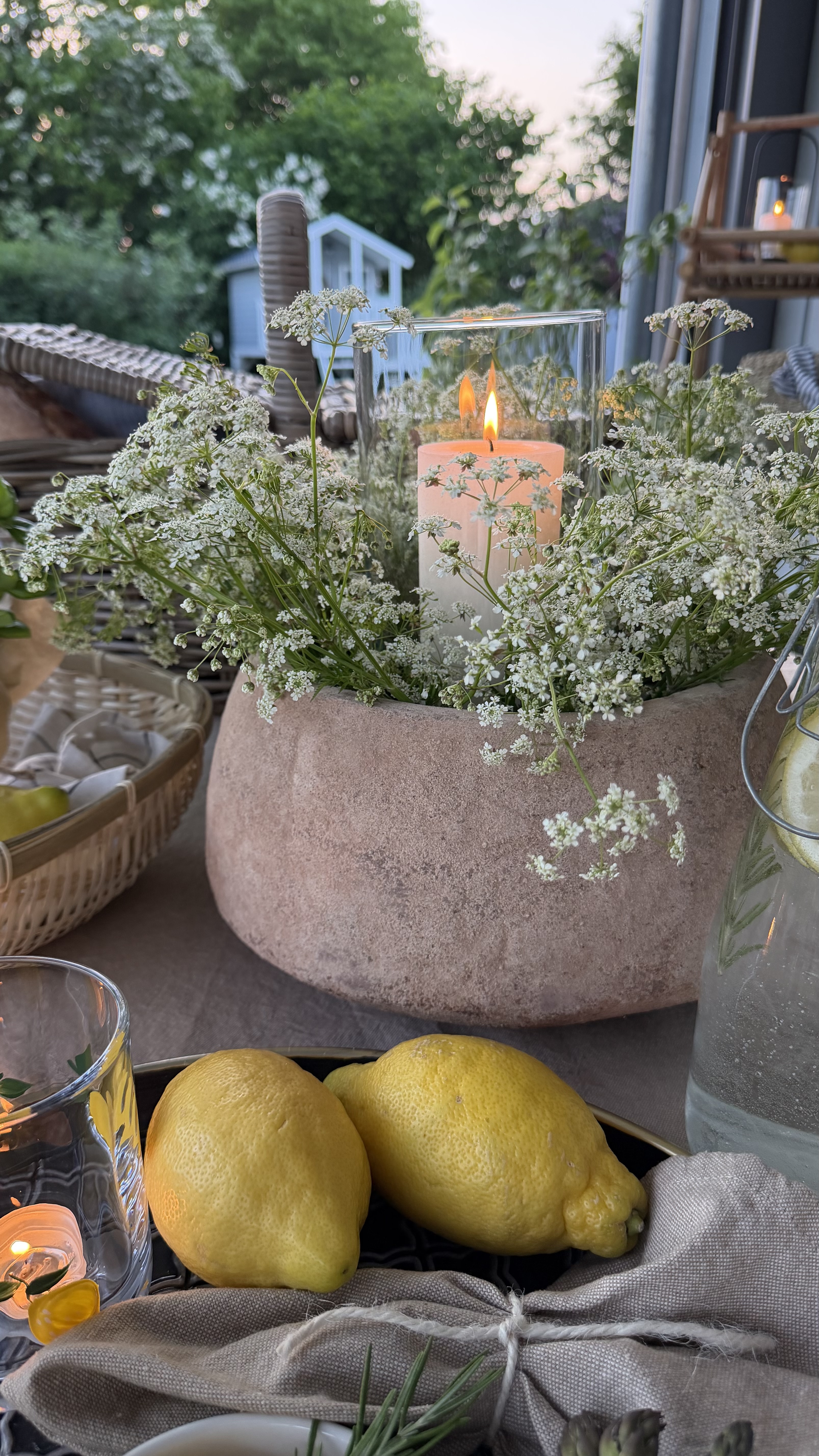 Gartendeko: Pflanzschale mit weißen Blumen und Kerze im Glas als stimmungsvolle Terrassendeko