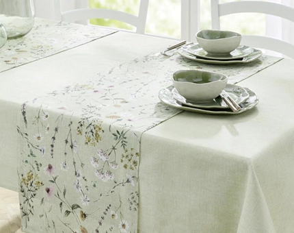 Frühlingshafte Tischdeko mit mintgrüner Tischdecke und floralem Tischläufer auf weißem Esstisch