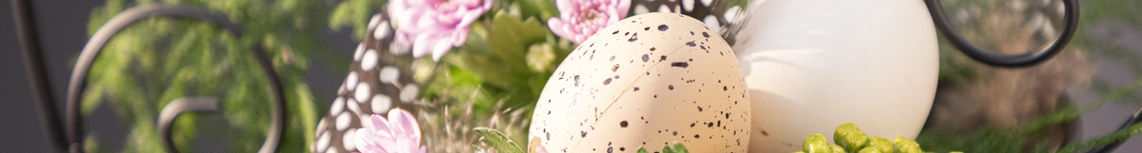 Osterdeko: cremefarbene und gesprenkelte Dekoeier mit rosa Blumen als frühlingshafte Tischdeko