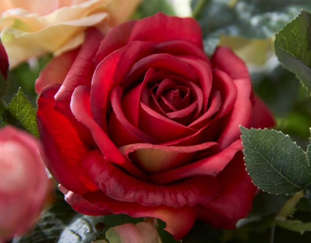 Kunstpflanzen: rote Kunstrose mit grünen Blättern als langlebige Blumendekoration